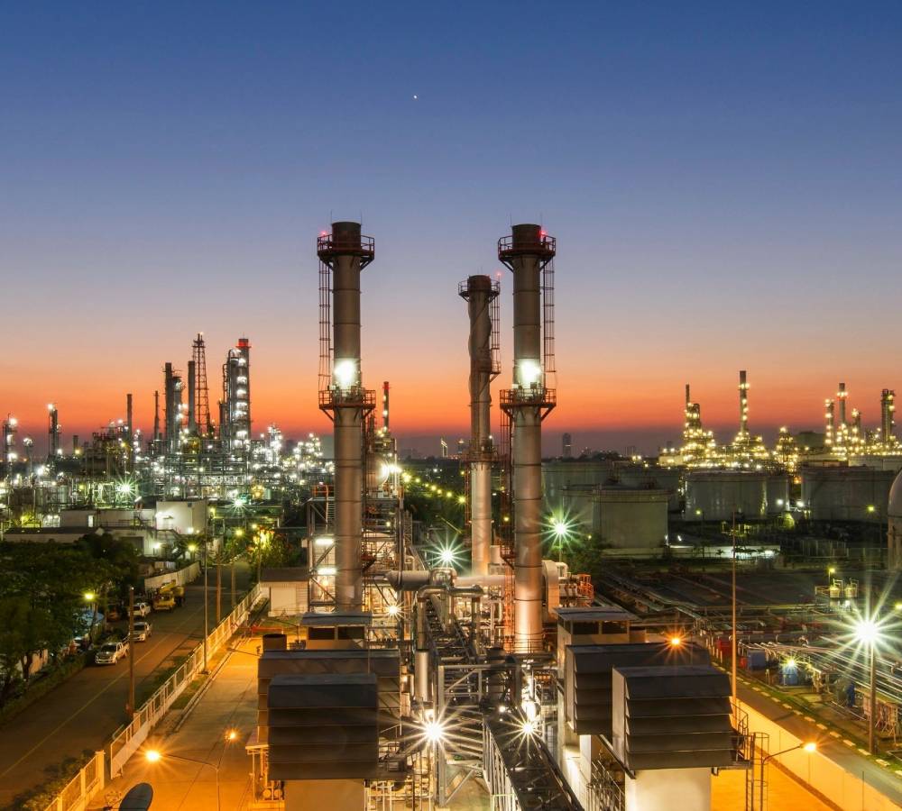 A large oil refinery with many towers and pipes.