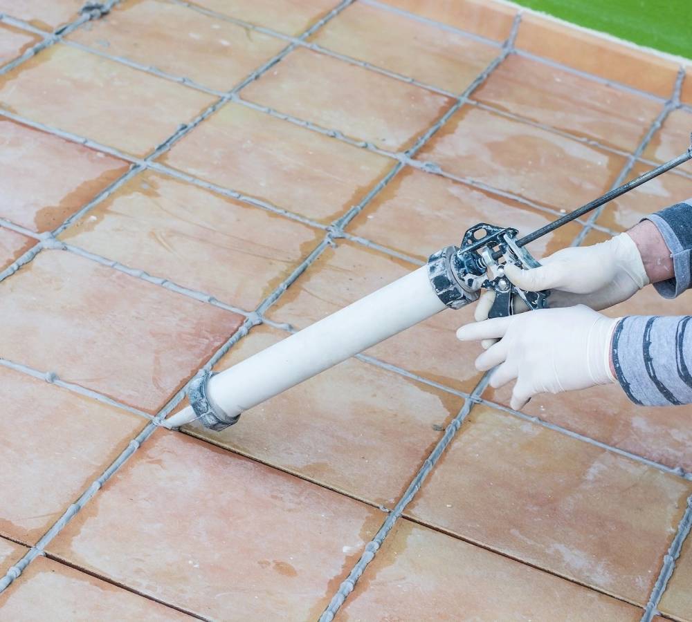 A person is using a hose to clean the roof of a house.